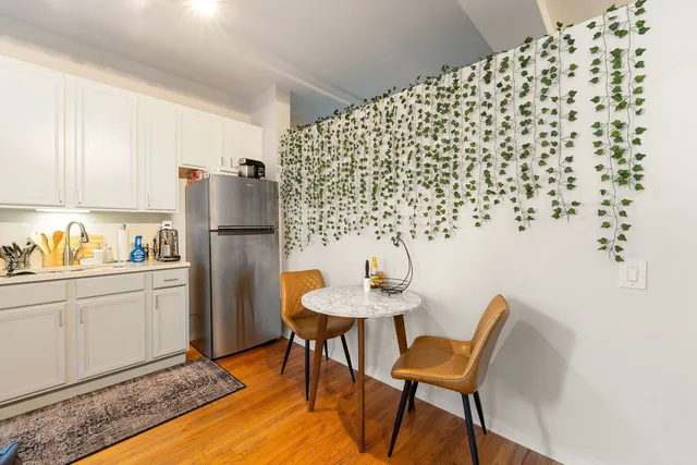 a living room with furniture and a refrigerator