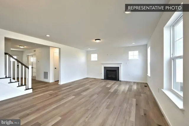 a view of empty room with wooden floor and fireplace
