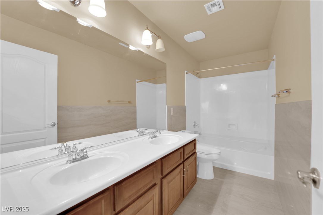 1142 Sax Fifth Avenue Henderson, NV 89052 - Photo 25 of 44 Bright full bathroom featuring double sinks and a large tub/shower combo.