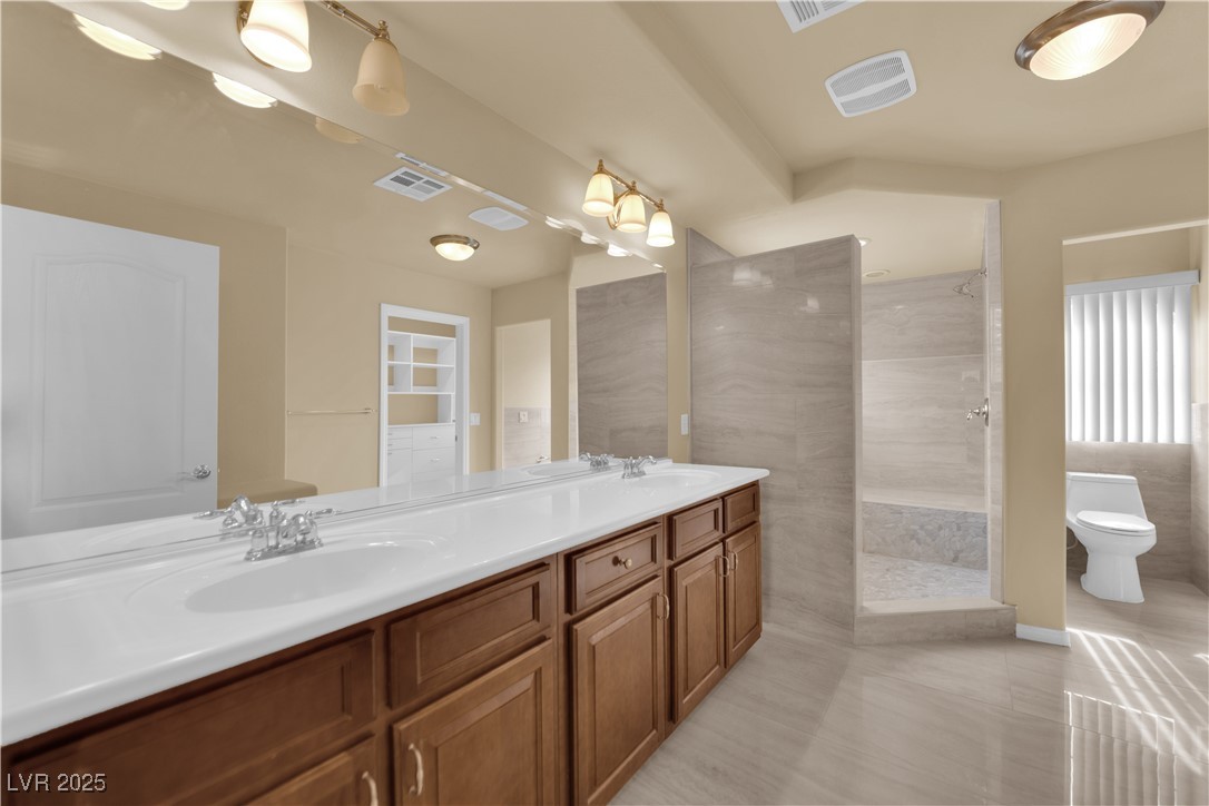 1142 Sax Fifth Avenue Henderson, NV 89052 - Photo 35 of 44 Primary bathroom featuring double sinks, extended vanity, and upgraded lighting.
