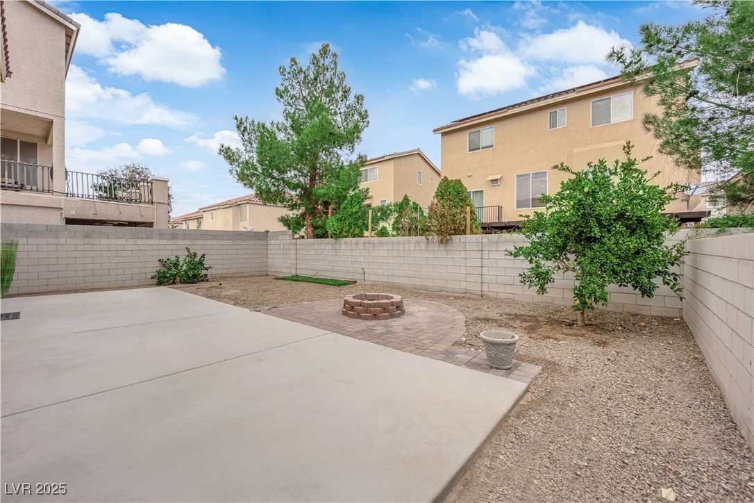 1142 Sax Fifth Avenue Henderson, NV 89052 - Photo 40 of 44 Low-maintenance backyard with extended patio and brick fire pit area—perfect for entertaining.