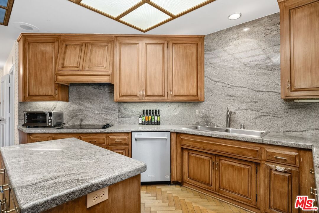10114 Empyrean Way, Unit 302 Los Angeles, CA 90067 - Photo 11 of 37 a kitchen with stainless steel appliances granite countertop wooden cabinets and a granite counter tops