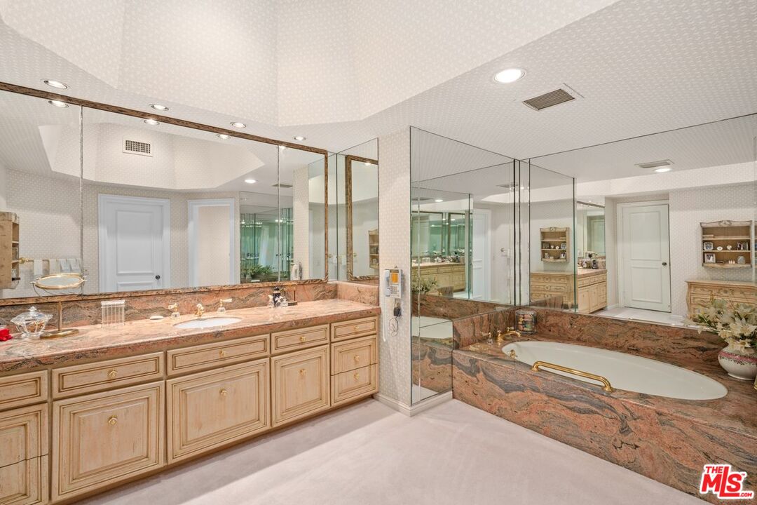 10114 Empyrean Way, Unit 302 Los Angeles, CA 90067 - Photo 22 of 37 a spacious bathroom with a sink mirror and a bath tub