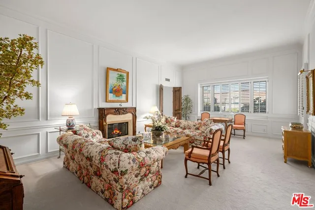 a living room with fireplace furniture and a large window