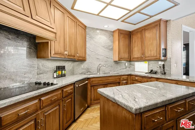 a kitchen with granite countertop a sink a stove and cabinets