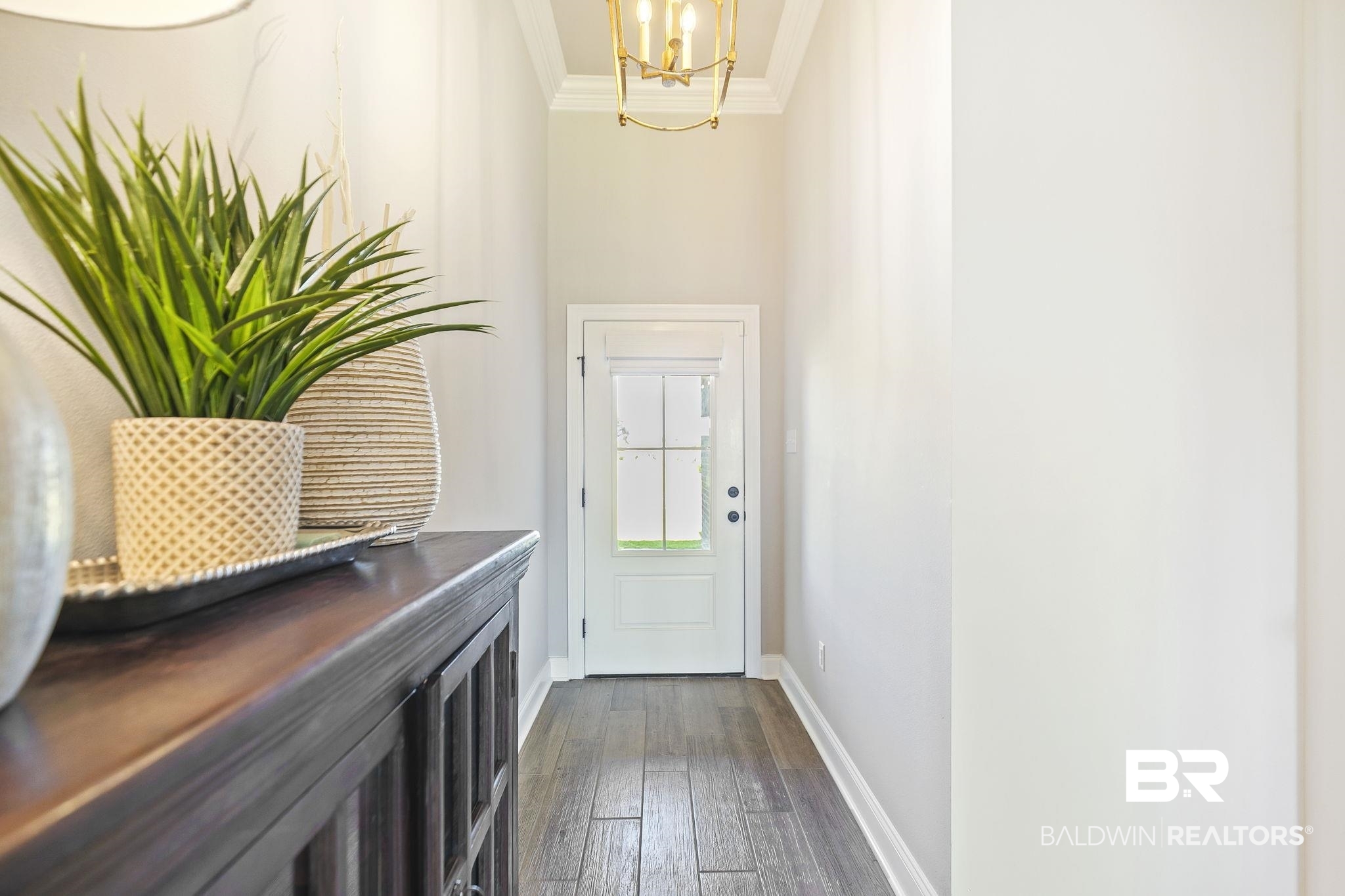 10140 Chipper Lane Foley, AL 36535 - Photo 10 of 72 Doorway featuring dark hardwood / wood-style floors, a chandelier, and ornamental molding