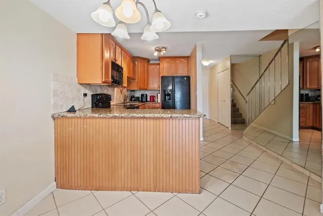 a kitchen with stainless steel appliances a sink a refrigerator and cabinets