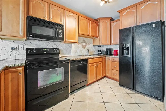 a kitchen with stainless steel appliances granite countertop a refrigerator stove top oven and sink