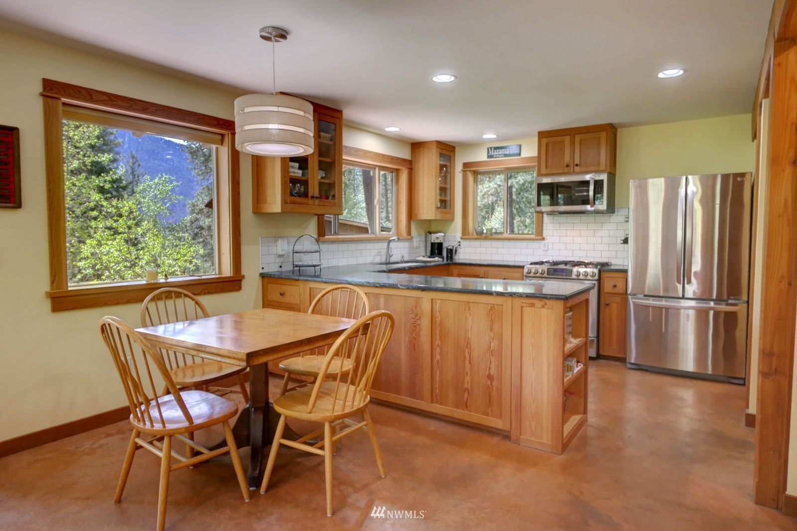 22 Trillium Road Winthrop, WA 98862 - Photo 13 of 40 a kitchen with stainless steel appliances granite countertop a stove a refrigerator a sink a dining table and chairs with wooden floor