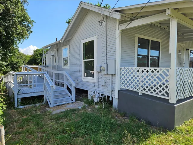 a view of a house with wooden deck front of house