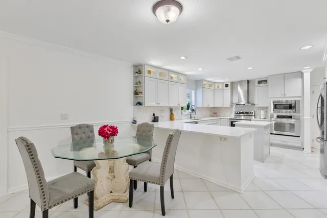 a kitchen with white cabinets and stainless steel appliances