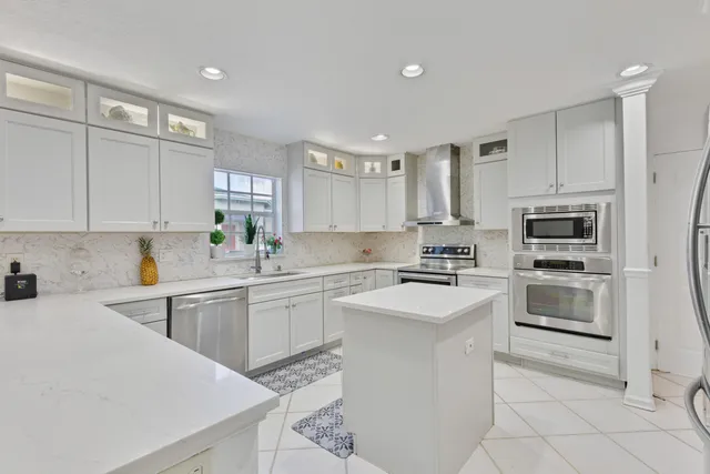 a kitchen with white cabinets appliances and white appliances