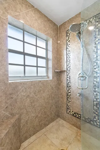 a spacious bathroom with a granite countertop double vanity sink a bathtub a mirror and vanity