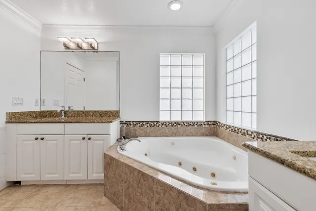 a bedroom with a bed and a dresser next to a window