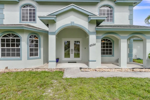 a living room with furniture and a mirror