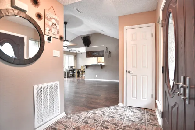 a view of a hallway with wooden floor and a living room