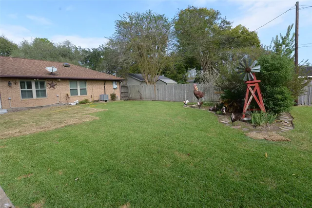 a view of a house with a backyard and a tree