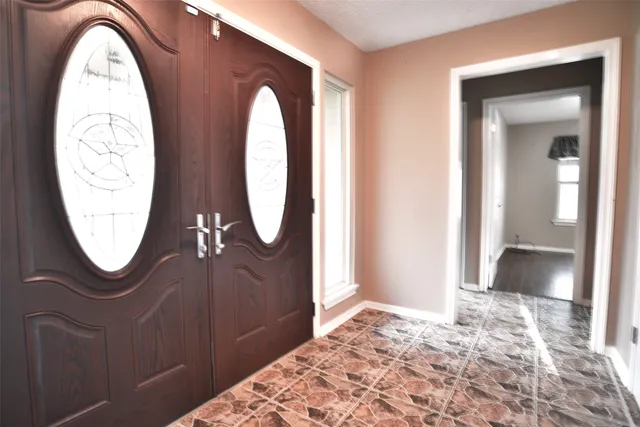 an empty room with wooden floor mirror and outdoor view