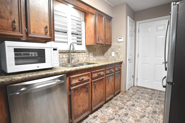 a kitchen with stainless steel appliances granite countertop a sink stove and cabinets