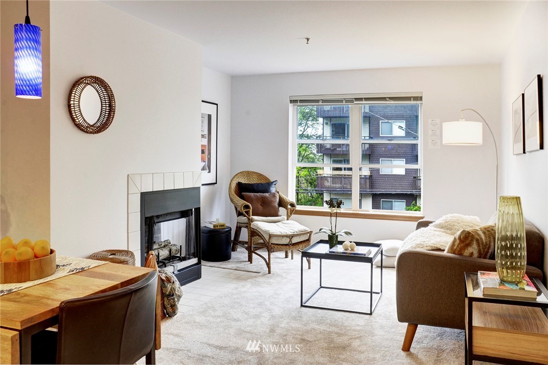 3901 Fremont Avenue North, Unit 206 Seattle, WA 98103 - Photo 3 of 15 a living room with furniture a fireplace and a large window