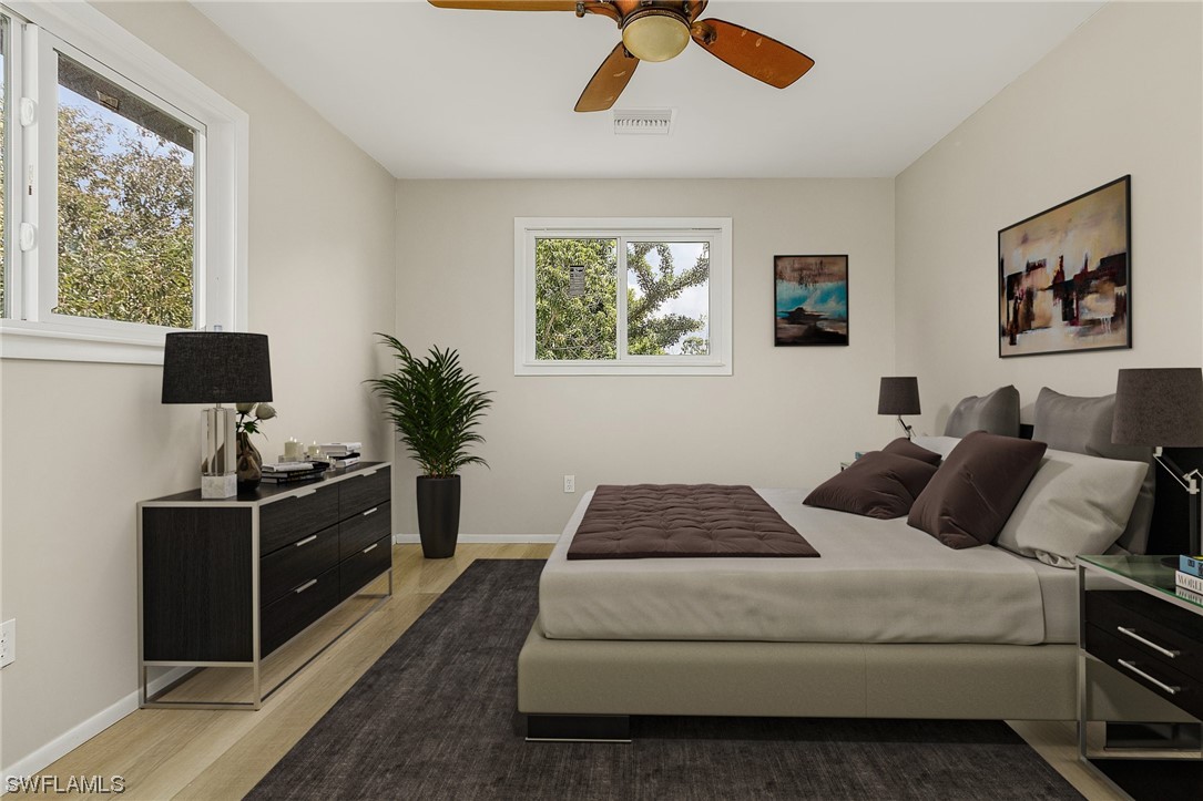 14230 Robert Road Bokeelia, FL 33922 - Photo 13 of 22 a bedroom with a large bed and a window