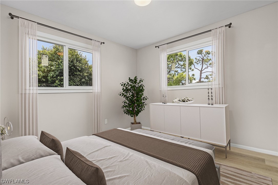 14230 Robert Road Bokeelia, FL 33922 - Photo 14 of 22 a bedroom with a bed and a window