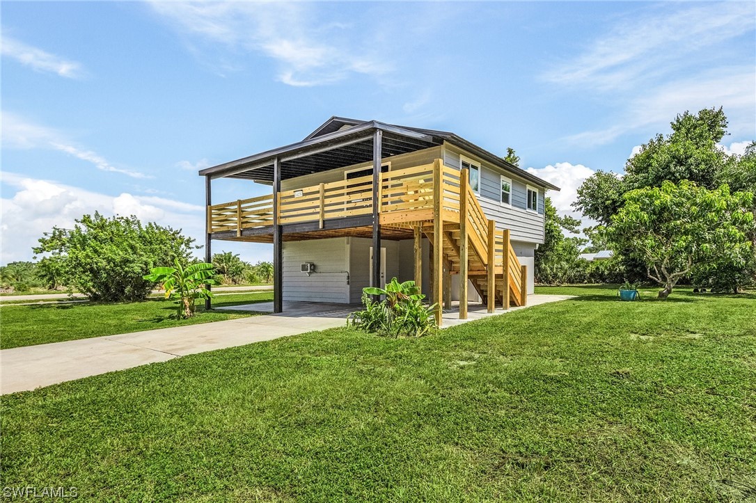 14230 Robert Road Bokeelia, FL 33922 - Photo 2 of 22 a view of a house with a yard and pathway