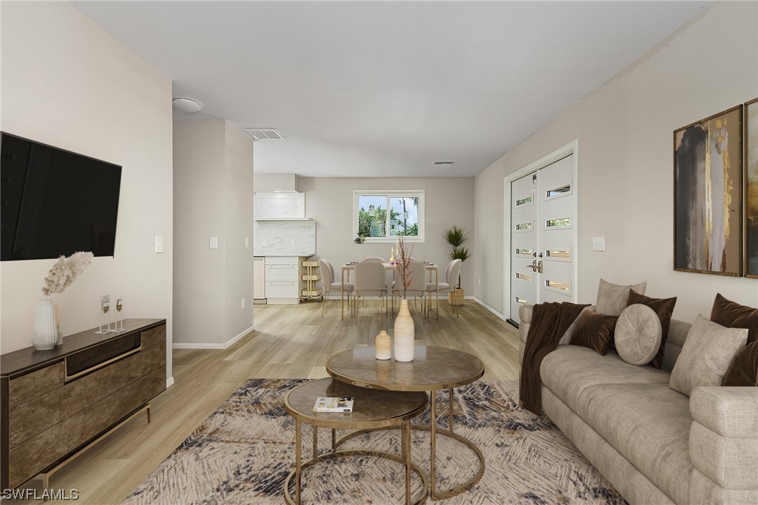 14230 Robert Road Bokeelia, FL 33922 - Photo 6 of 22 a living room with furniture a flat screen tv and kitchen view