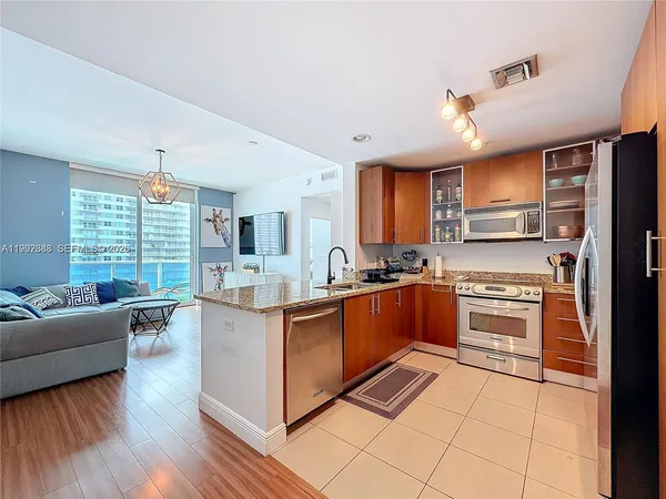 a large kitchen with stainless steel appliances granite countertop a stove and cabinets