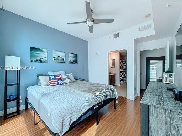 a bedroom with a bed and wooden floor