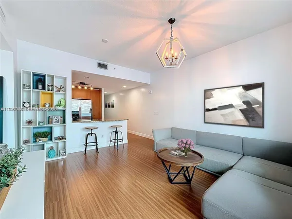 a view of a dining room with furniture wooden floor and a chandelier