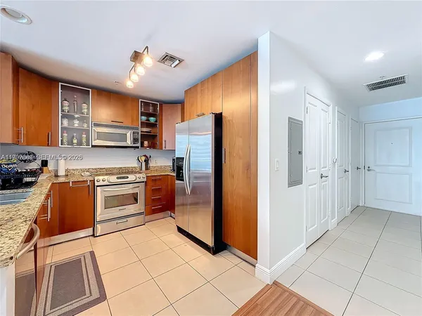 a kitchen with stainless steel appliances granite countertop a refrigerator and a stove top oven