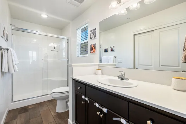 a bathroom with a sink a toilet and shower