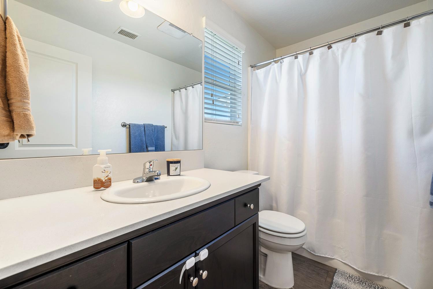 3780 Highclere Way Clovis, CA 93619 - Photo 14 of 21 a bathroom with a sink a toilet and a mirror