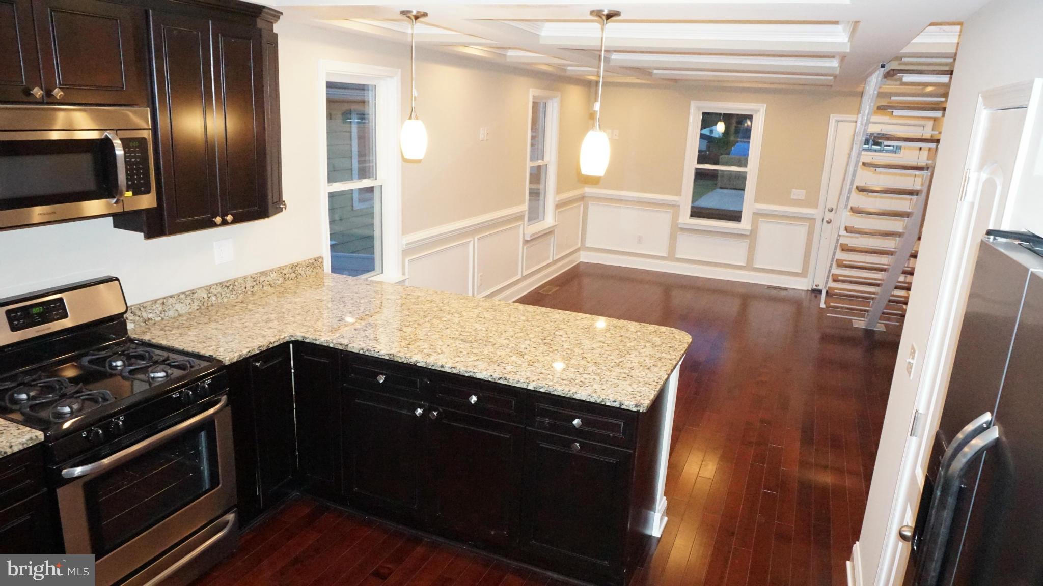 6922 Sollers Point Road Baltimore, MD 21222 - Photo 3 of 30 a kitchen with granite countertop stainless steel appliances and wooden cabinets