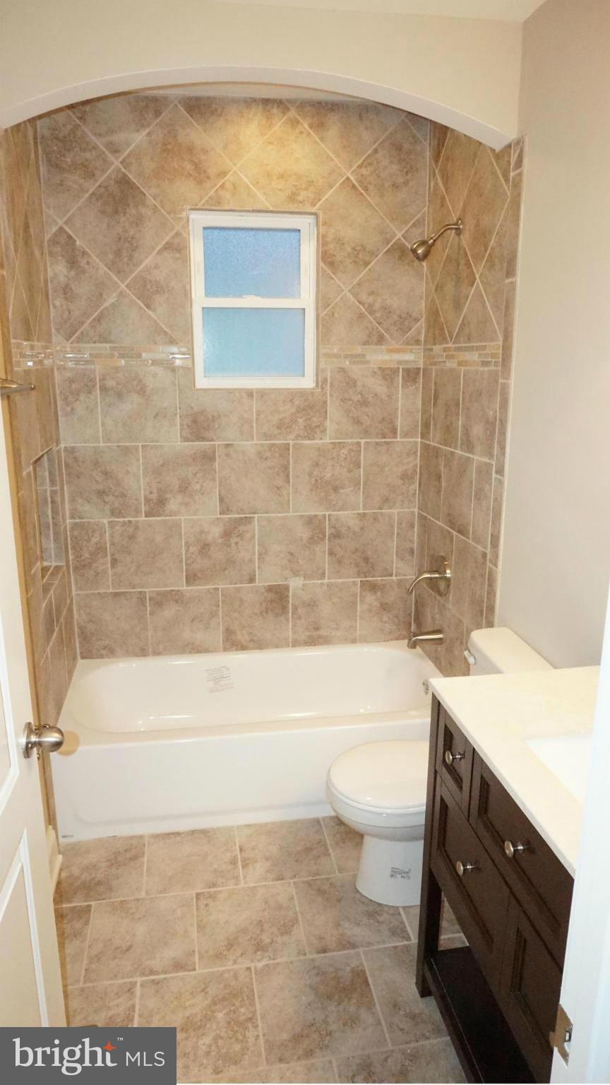 6922 Sollers Point Road Baltimore, MD 21222 - Photo 6 of 30 a bathroom with a sink a bathtub and a toilet