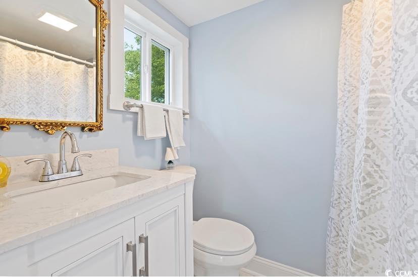 1044 Levi Street Manning, SC 29102 - Photo 16 of 26 Bathroom with vanity, toilet, baseboards, and curtained shower