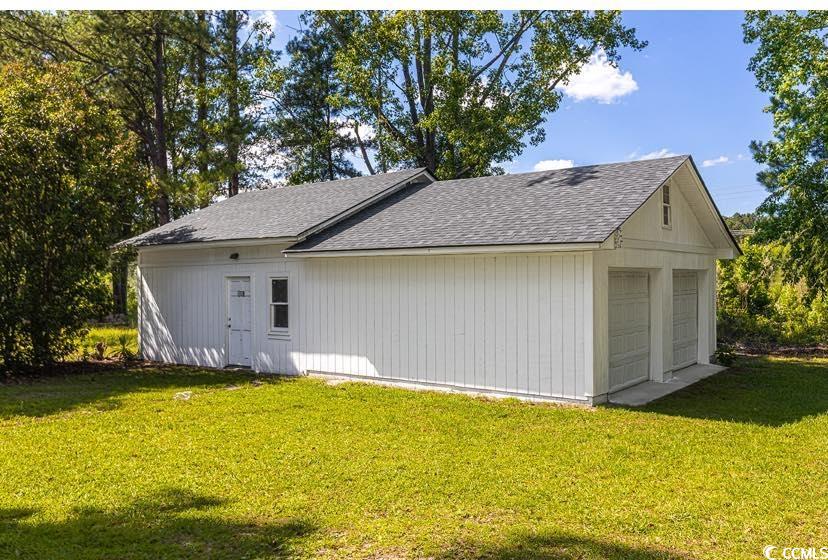 1044 Levi Street Manning, SC 29102 - Photo 21 of 26 View of home's exterior with roof with shingles, a garage, and a lawn