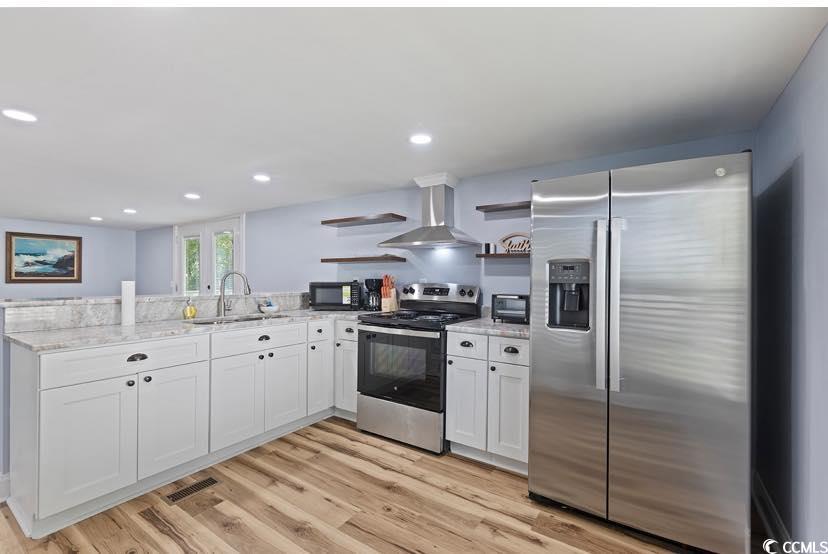 1044 Levi Street Manning, SC 29102 - Photo 7 of 26 Kitchen featuring appliances with stainless steel finishes, a sink, open shelves, wall chimney exhaust hood, and a peninsula