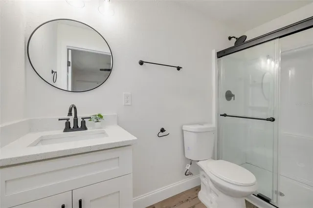 a bedroom with a bed and hardwood floor