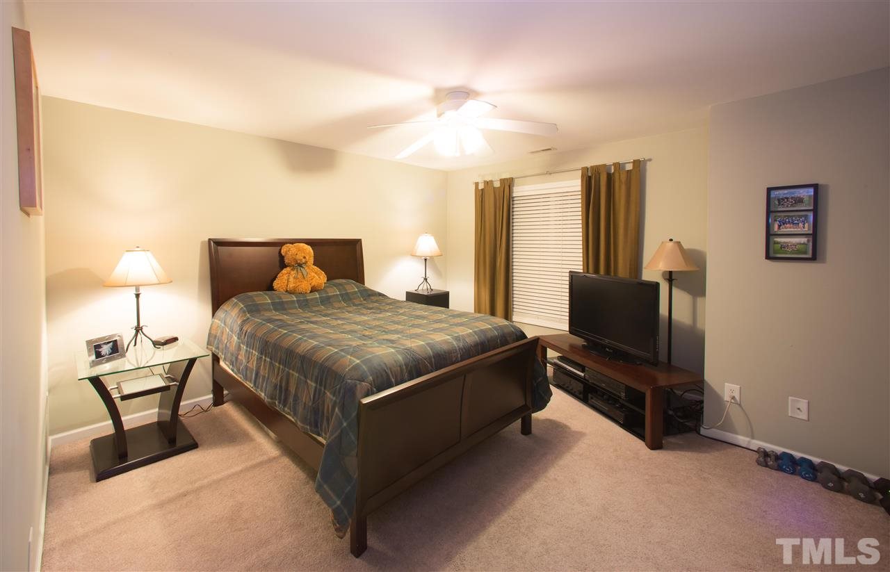 3545 Sunbright Lane Raleigh, NC 27610 - Photo 18 of 25 a bedroom with a bed wooden floor and lamp on table