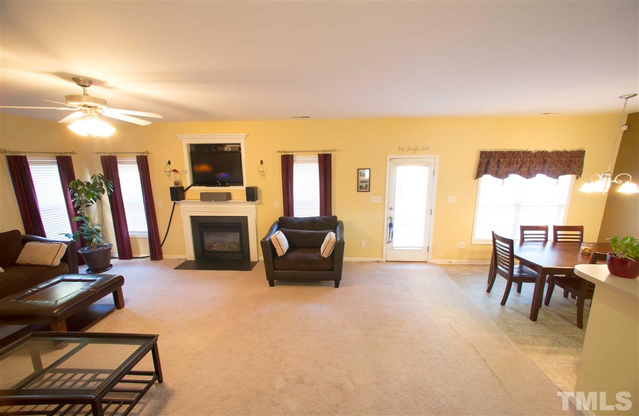 3545 Sunbright Lane Raleigh, NC 27610 - Photo 7 of 25 a living room with furniture a fireplace and a flat screen tv