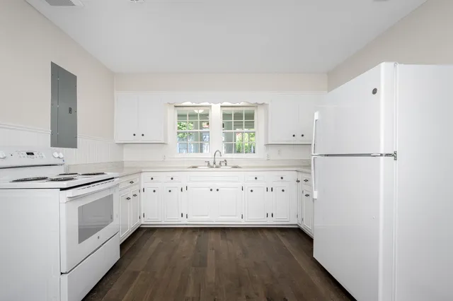 a kitchen with granite countertop white cabinets and white appliances