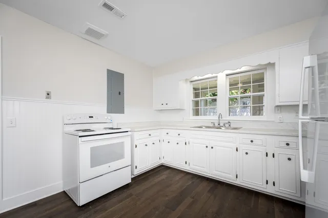 a kitchen with granite countertop white cabinets and white appliances