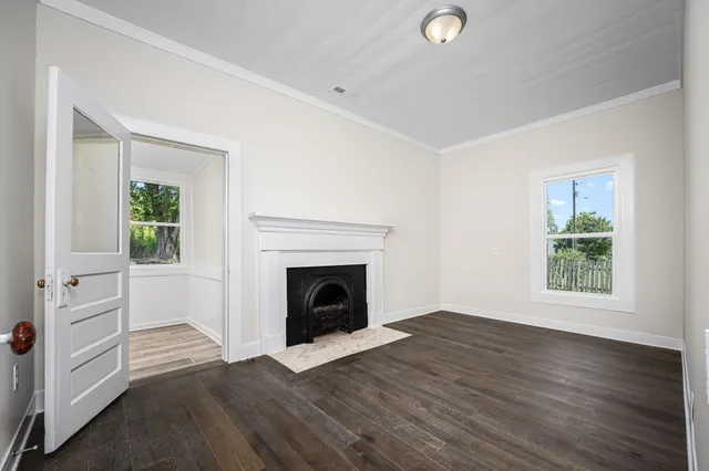an empty room with windows and fireplace