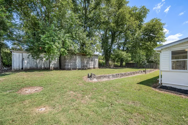 a view of a house with a yard and a tree