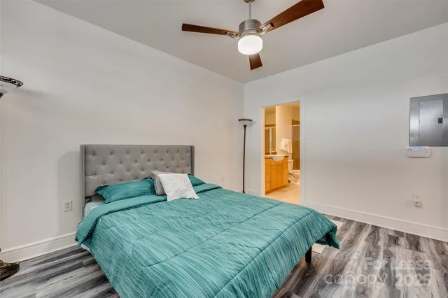 a spacious bathroom with a granite countertop sink toilet mirror and shower
