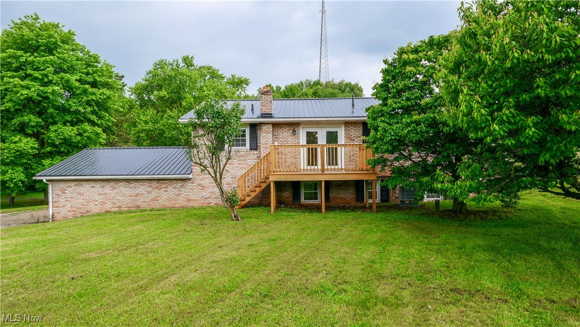 23595 Sandy Creek Road Minerva, OH 44657 - Photo 26 of 32 Rear view of property with stairway, a chimney, a wooden deck, brick siding, and a yard