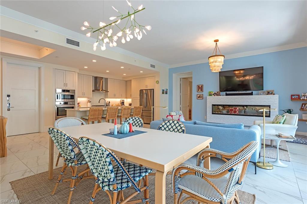 1135 3rd Avenue South, Unit 308 Naples, FL 34102 - Photo 5 of 18 a view of a dining room with furniture and a chandelier