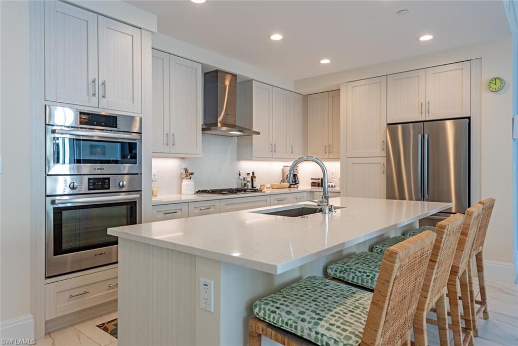 1135 3rd Avenue South, Unit 308 Naples, FL 34102 - Photo 6 of 18 a kitchen with stainless steel appliances granite countertop a refrigerator and a stove top oven